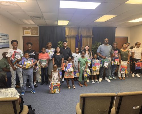 Group of Students of Various Ages Standing with Back to School Donations